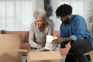 Son helping elderly mother unpack boxes after moving into assisted living