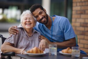 Caregiver having special moment with resident as they share meal together while sitting outside