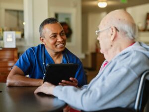 A healthcare worker attending to a senior citizen resident in an assisted living facility